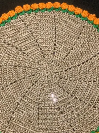This is from my tulip collection, featuring a simple beige doily with a vibrant orange tulip border. The 3D effect of the tulips makes it a unique piece.