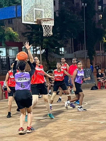 A player from the women's division attempts a shot over the outstretched arms of a defender.