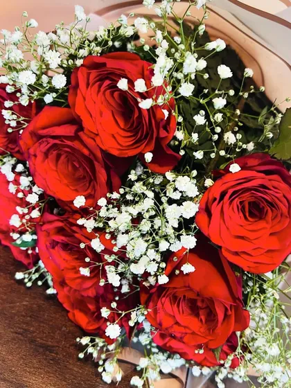 A close-up shot of deep red roses nestled in baby's breath. This image highlights the fresh quality and rich color of the flowers I use in my arrangements.