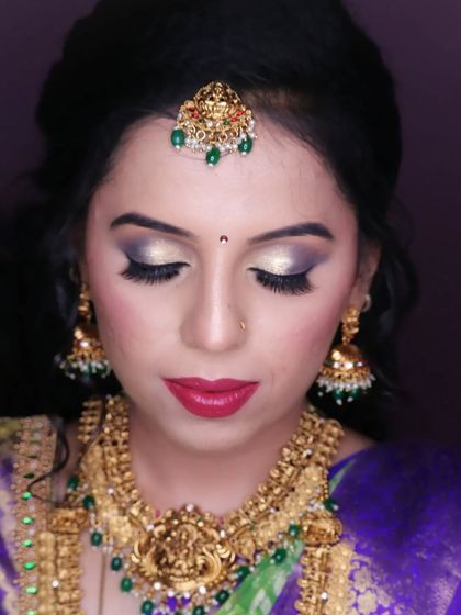 Chaithra all set for her reception. We created a glamorous look with a golden smokey eye and a bold red lip, which looks stunning with her antique gold jewellery.