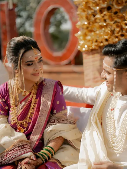 Our Maharashtrian bride's look is a true celebration of tradition. This candid shot captures a beautiful moment between the couple during their wedding ceremony.