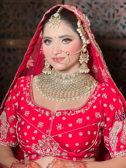 A portrait of a bride looking radiant in her red wedding attire. The makeup, jewelry, and outfit all come together for a perfect bridal look.