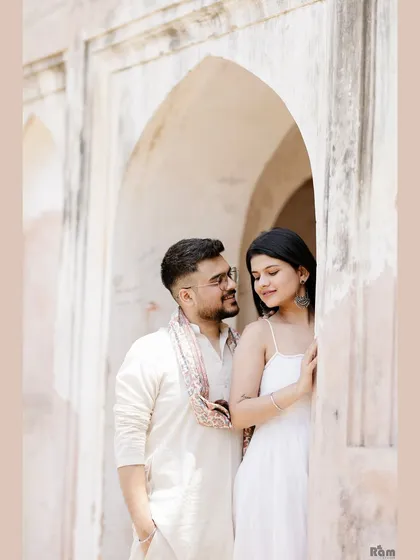 An intimate portrait framed by the archway of a historic monument. The soft light and gentle expressions highlight the couple's deep connection during their Delhi pre-wedding shoot.