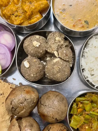 The heart of a Rajasthani meal: Dal, Bati, Churma, and Gatte ki Sabzi, served in traditional steel bowls.