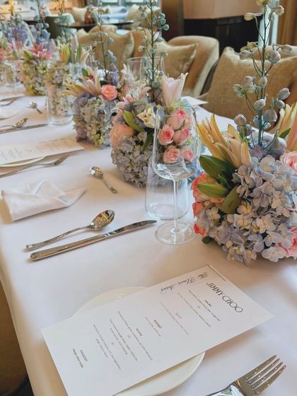 A detailed view of the tablescape for the Jimmy Choo launch, showing the custom menu card placed next to a beautiful floral arrangement. Every element is curated to align with the brand's luxury identity.