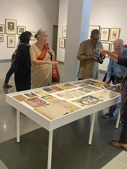 The artist, his wife, and the curator in discussion over the archival materials.