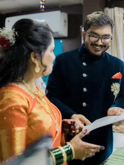 A candid shot of the couple smiling as they review their marriage documents, a key moment in their official union.