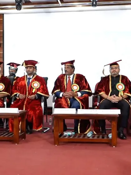 Seated on the dais with other dignitaries and the college faculty during the graduation ceremony.