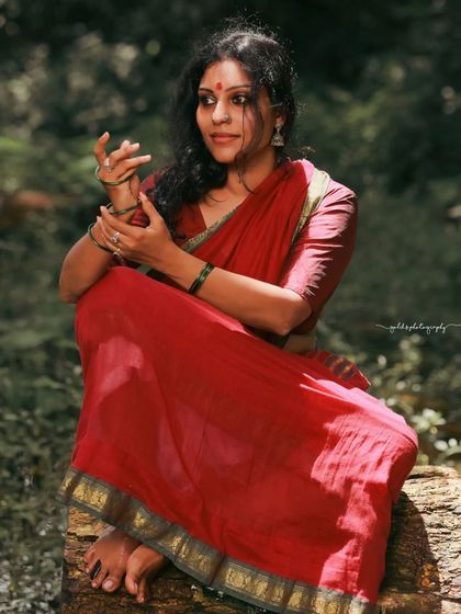 A rustic, village-themed series inspired by the movie 'Kanthara'. The model is styled in a simple red saree, captured in a natural, watery landscape to evoke a sense of raw, earthy beauty.