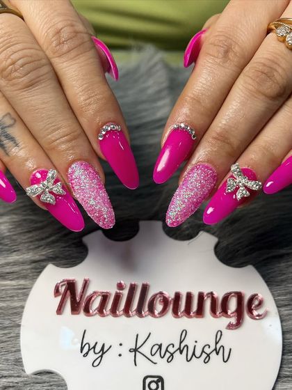 A vibrant hot pink set with glitter accent nails and sparkling 3D rhinestone bows.
