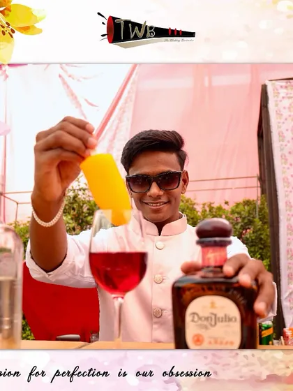 A bartender at a Mehendi celebration, expertly crafting a colorful cocktail with a smile.