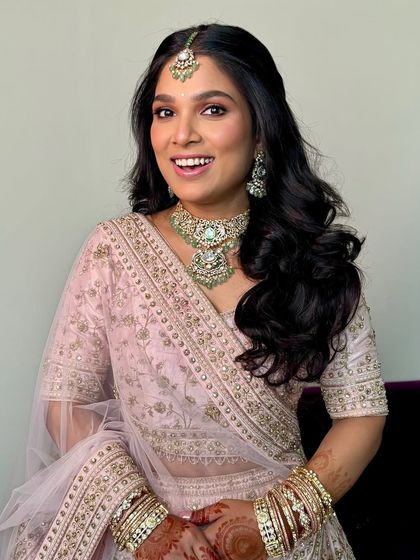 A happy, smiling portrait of the bride. Her soft pink makeup and wavy hair create a look that is both classic and fresh.