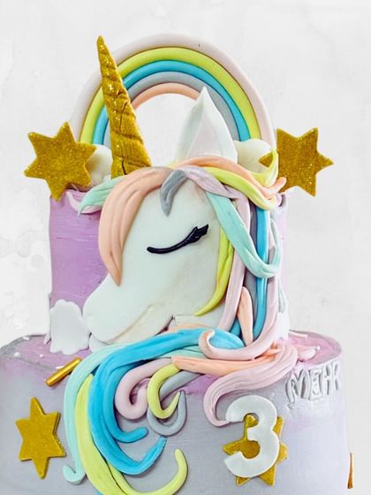A close-up on the beautifully sculpted unicorn head, with its pastel rainbow mane and golden horn. Every detail is handcrafted and edible.