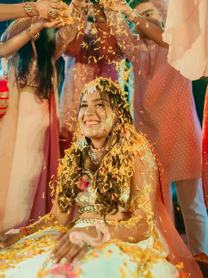 A fun "phoolon waali haldi" moment, with the bride's hair still looking beautiful.