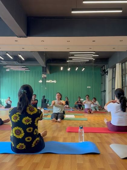 A wide shot of a class in a seated position, preparing for a core exercise. You can see the focus and community atmosphere that defines our sessions.