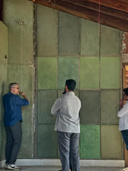 Our team studies a wall of green-hued plaster samples on-site at the Kamshet farmhouse. This hands-on process of testing colors and textures in the actual space is crucial to achieving the perfect finish.