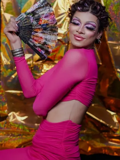 The fan prop adds a classic element of drag performance to the photoshoot.