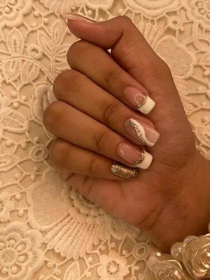 A chic and simple design featuring a modern French tip with a gold glitter wave accent. This is a versatile look for any celebration.