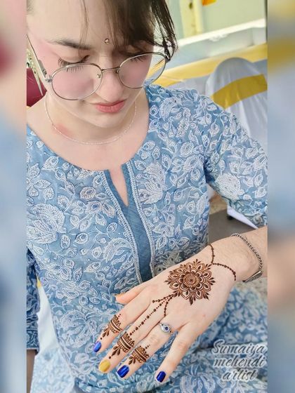 A minimal yet beautiful design for a wedding guest, featuring a central mandala connected to the finger with a delicate chain.