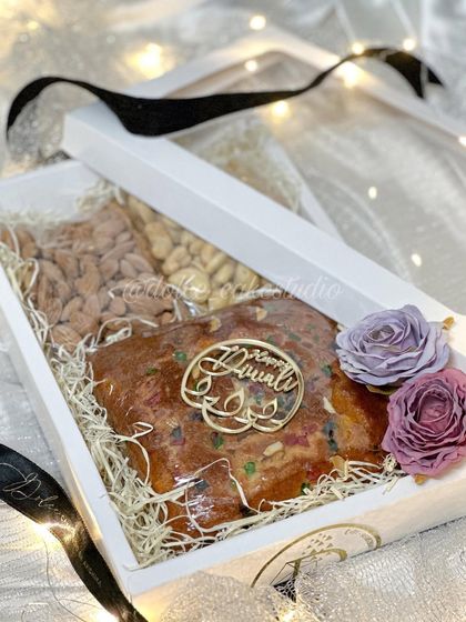 Here’s what my Diwali box hamper looks like when you open it. The tea cake and nuts are nestled in shredded paper to keep them safe, decorated with a 'Happy Diwali' tag and reusable flowers.