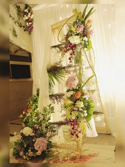 A decorative ladder adorned with cascading floral arrangements, a unique and artistic decor element.