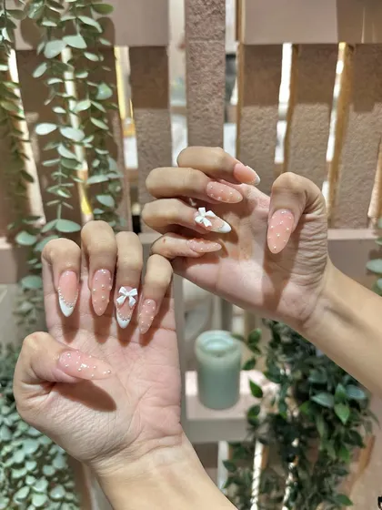 A still shot capturing the sparkle and detail of these bow and polka dot nails. We love creating designs that are packed with cute details.