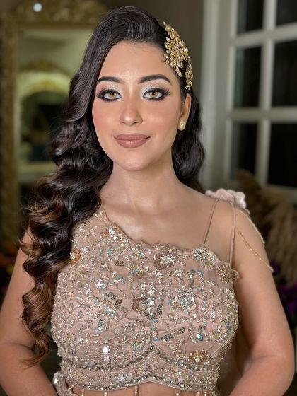 A signature party look. This features a beautiful beige gown, a soft smokey eye, and Hollywood waves with a hair accessory.