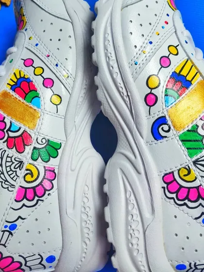 A pair of plain white sneakers transformed with vibrant, hand-painted floral and mandala-inspired patterns, showcasing my custom wearable art service.