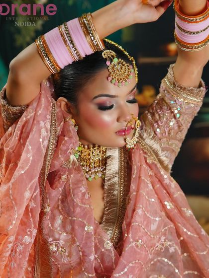 An expressive pose that highlights the soft, flowing fabric of the outfit and the delicate makeup.