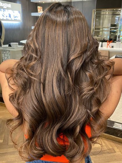 This shot captures the full length and dimension of the French mocha balayage, styled in soft waves.
