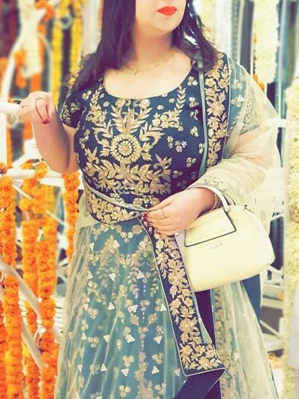 A closer look at the intricate gold floral embroidery on the bodice of the dark green Anarkali. The matching dupatta completes this classic ethnic wear look.