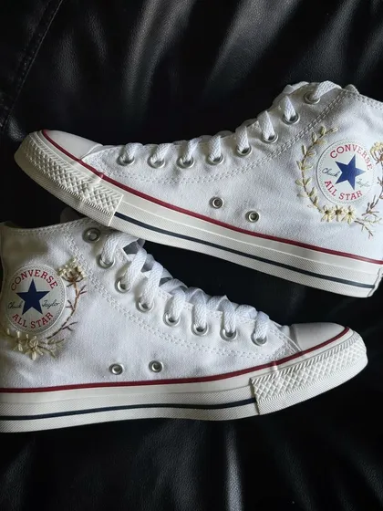A pair shot showing the embroidery on both sides of the Converse.