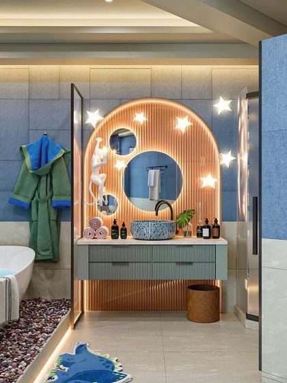 A creative kids' bathroom design with star-shaped lights around the vanity. The blue and orange color scheme is fun and energetic.