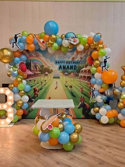 A cricket-themed birthday party for an 8-year-old sports fan. The decoration includes a stadium backdrop, a balloon arch in team colors, and a light-up marquee number '8', creating a fun and sporty atmosphere.