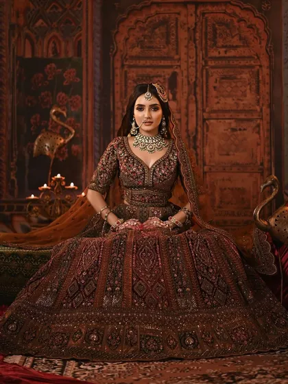 A full-length portrait of the model, showcasing the grandeur of the lehenga and the dramatic, candle-lit setting.