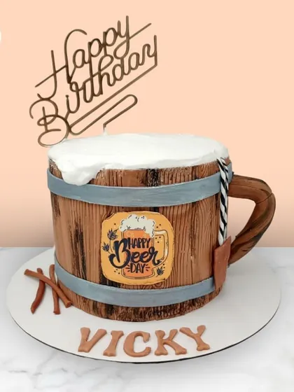 A fun and creative beer mug cake for Vicky's "Beer Day," complete with a frothy top and wooden barrel texture.
