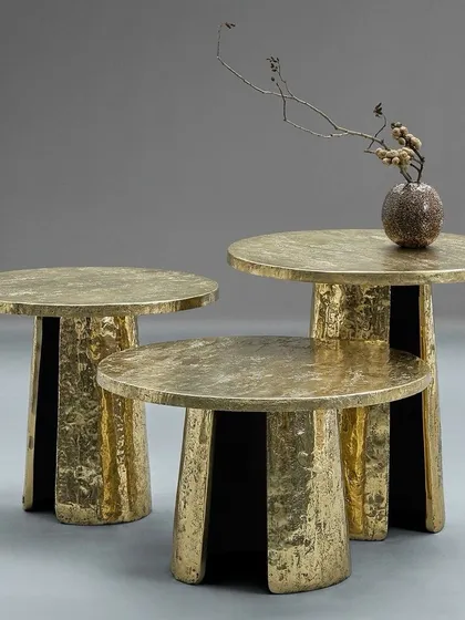 This set of nesting tables features a hand-hammered texture, giving the rustic gold PVD finish a unique, artisanal quality. They are a perfect example of how I create smaller, versatile accent pieces to complement a larger design scheme.