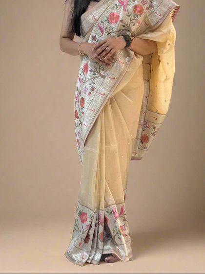 A fully draped look of the cream-colored tissue saree with a Paithani border, showing its classic elegance.