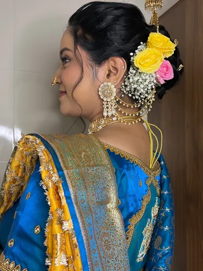 A view of the back, showing the elegant braided bun adorned with fresh flowers.