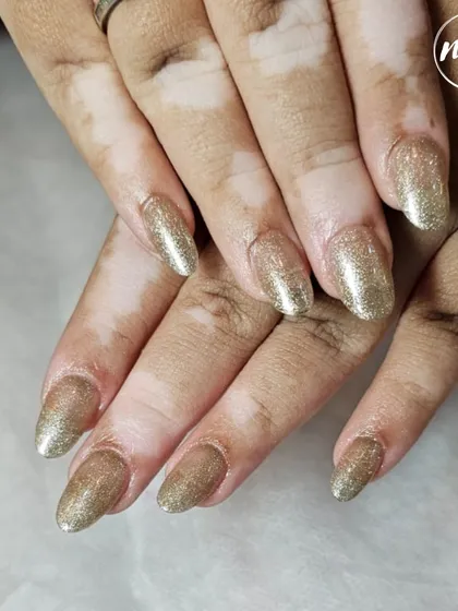 A classic and perfectly executed glitter gold nail extension set. This demonstrates a student's mastery of application, shaping, and finishing.