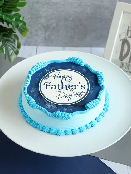 This Father's Day cake features a clean design with a decorative blue border and a "Happy Father's Day" plaque.
