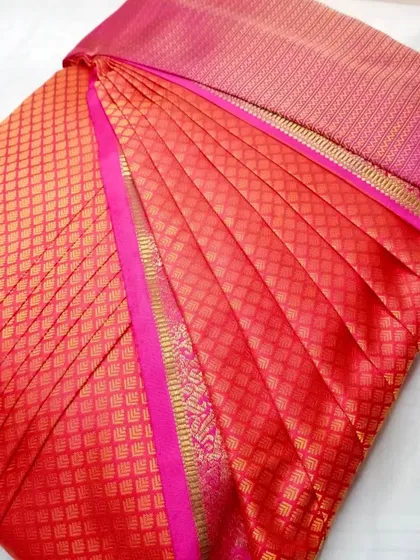 A red and pink silk saree, pleated and ready for any event.