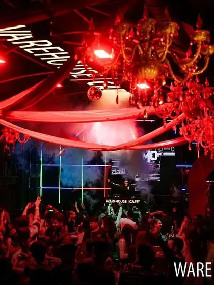 The ornate red chandeliers of Warehouse Cafe are visible in this wide shot, showing the unique decor of the venue.