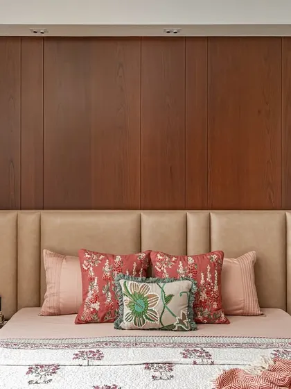 Natural light and warm wood tones define this master bedroom from our 'Oak Lodge' project. The custom leather headboard and integrated focus lights create a serene and timeless sanctuary, proving that elegance lies in simplicity and quality craftsmanship.