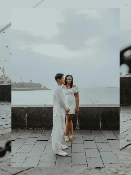 A beautifully framed portrait of the couple standing by the sea, creating a sense of intimacy and focus on their relationship.