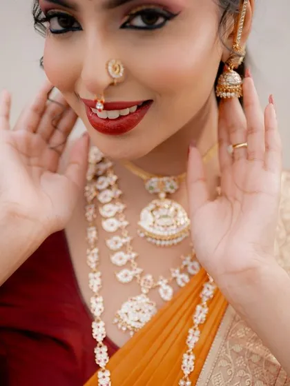 A close-up portrait focusing on the intricate jewelry and expressive face of a model in traditional attire. The shot highlights the beauty of both the model and the accessories.