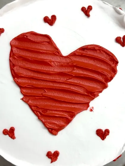 A close-up of the rustic, hand-painted heart on this minimalist cake.