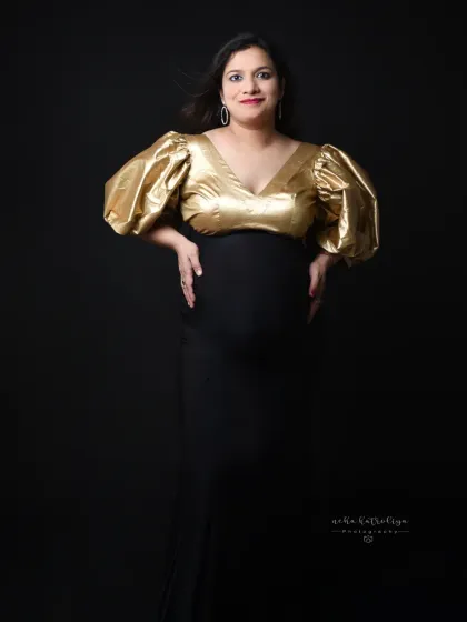 A confident, smiling portrait in the gold-and-black gown. This look is perfect for the mom-to-be who loves high fashion.