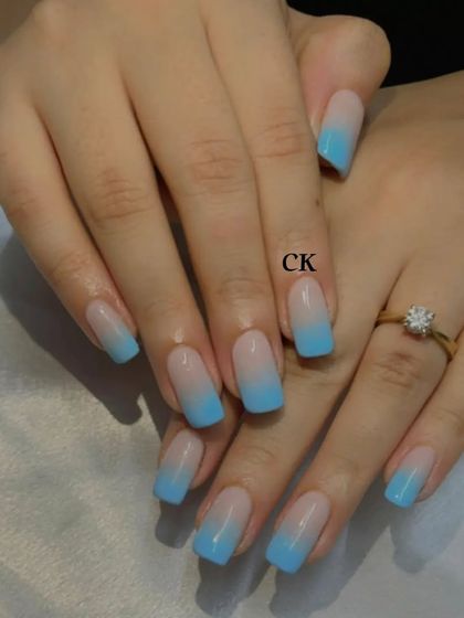 A beautiful blue ombre on square-shaped nails, fading from a nude base to a bright sky blue.
