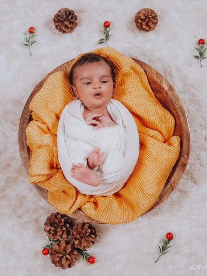 A charming top-down view of a yawning newborn, surrounded by festive props. This angle provides a unique and adorable perspective.